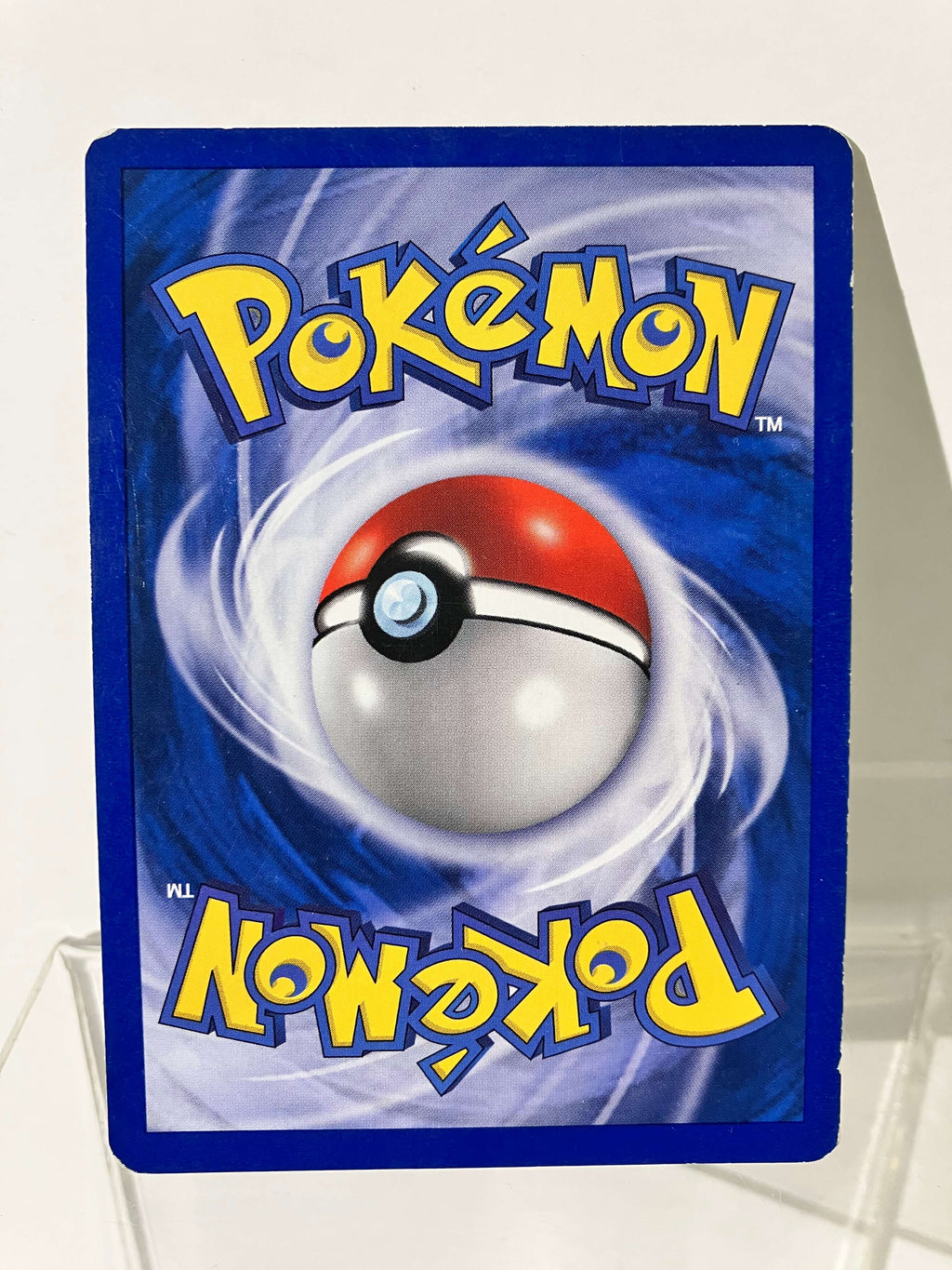 Carte Pokémon dos bleue, Pokéball au centre, texte jaune, fond tourbillonnant.