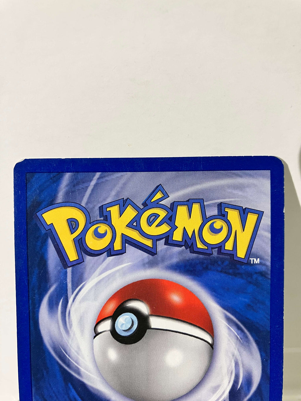 Dos d'une carte Pokémon officielle Pokéball, bordure bleue, fond blanc.