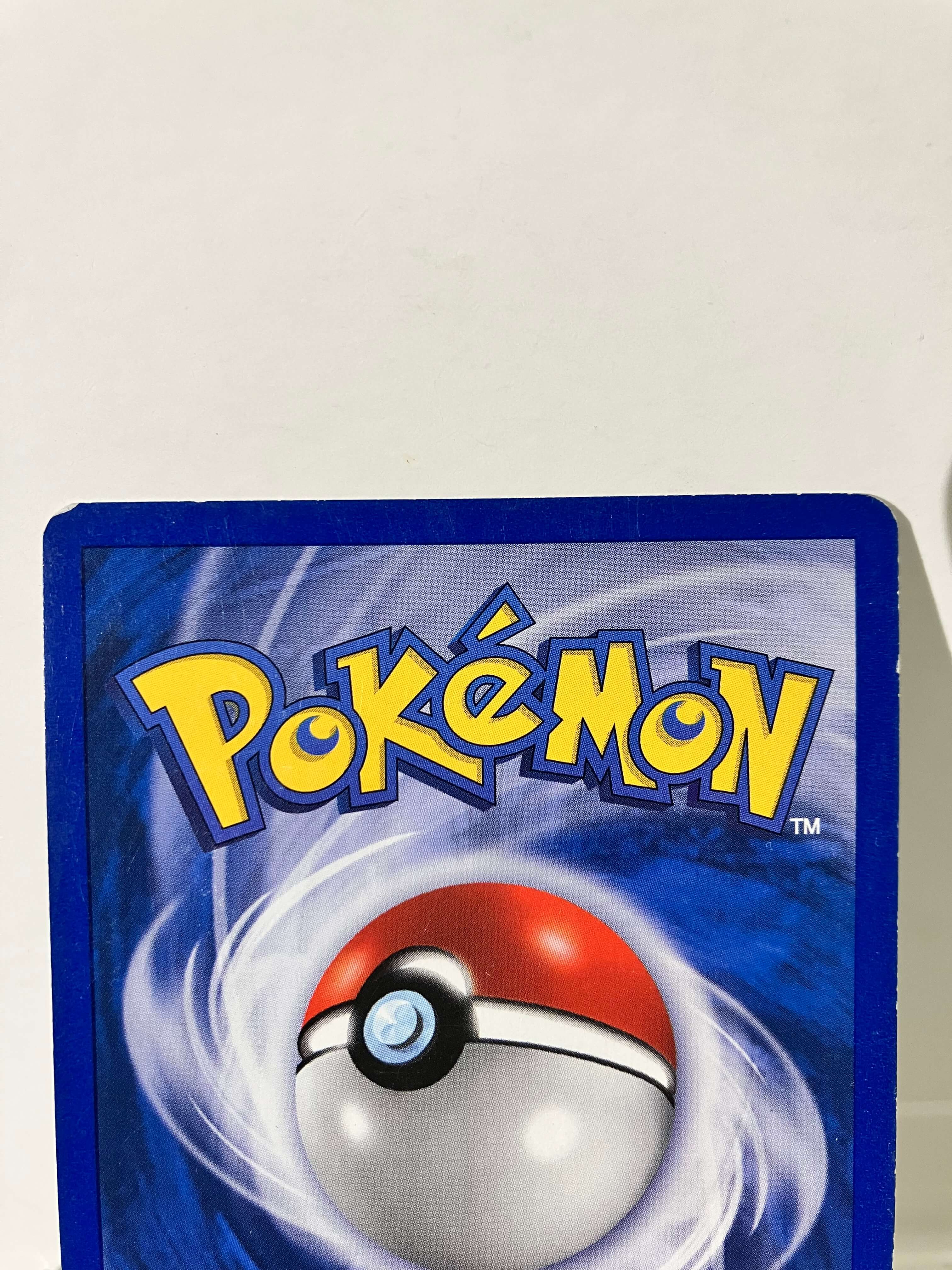 Dos d'une carte Pokémon officielle Pokéball, bordure bleue, fond blanc.