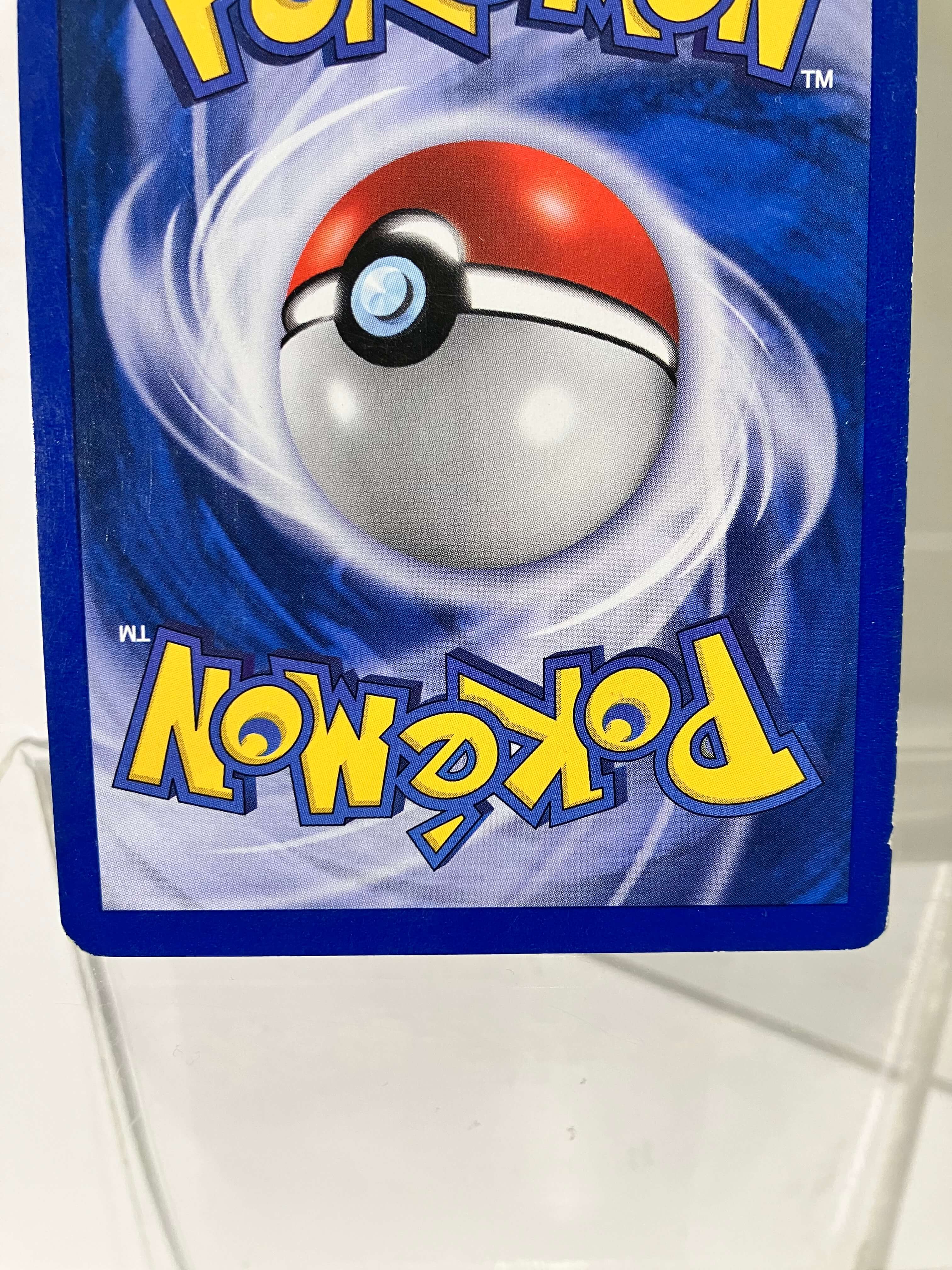 Dos de carte Pokémon officielle bleue avec Pokéball, logo jaune, carte à l'envers