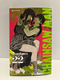 Couverture de manga Chainsaw Man tome 22 : Deux jeunes femmes en uniforme scolaire gris et blanc sont enlacées au centre de l’illustration. L’une porte l’autre dans ses bras tandis qu’elles échangent un regard complice. Le fond mêle des teintes vives de rose, vert et jaune évoquant un paysage végétal stylisé. Le titre Chainsaw Man apparaît en grandes lettres vertes sur le côté droit de la couverture.