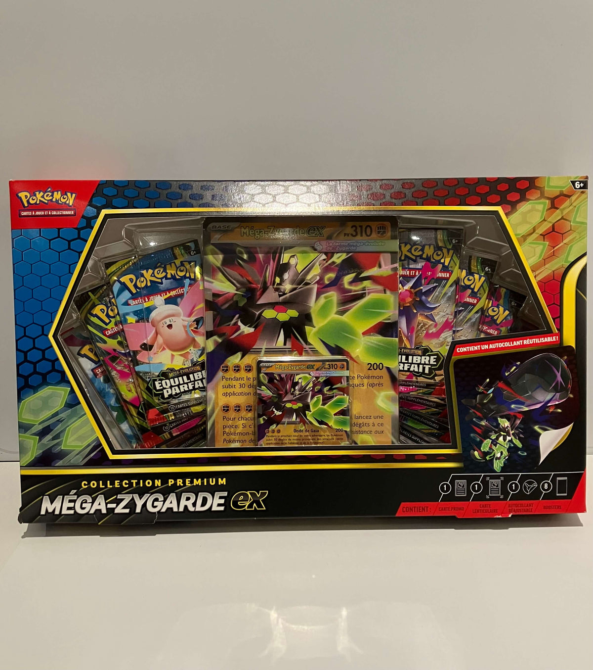 Boîte Pokémon « Coffret Pokémon Méga-Zygarde ex  » contenant plusieurs boosters, deux cartes promo et un autocollant.