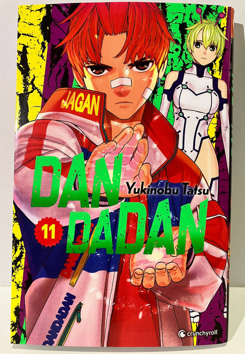 Couverture manga Dandadan tome 11, personnage roux avec veste rouge et fille en costume blanc futuriste.