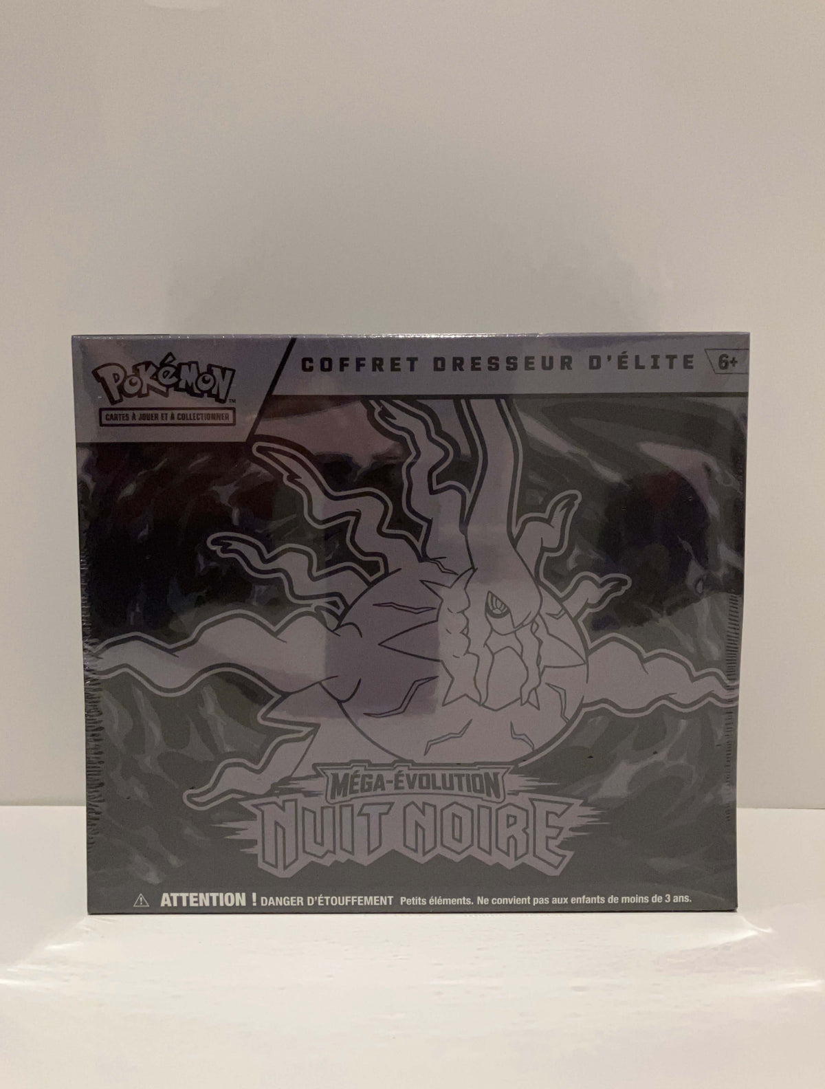 ce coffret dresseur d'élite contient 9 boosters de nuit noire, 1 carte promotionnelle brillante Illustration Rare, 65 protège-cartes, 40 cartes Énergie, 1 guide de jeu illustré de l'extension Nuit Noire, 6 dés marqueurs de dégâts, 1 dé lancer de pièce autorisé en tournoi officiel, 1 pièce en plastique à l'effigie de l'extension, coffret de rangement illustré avec 6 séparateurs inclus, 1 carte à code JCC Pokémon Live