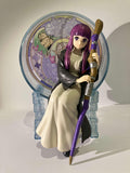 Figurine Fern Frieren assise avec bâton, fond coloré, décoration manga.
