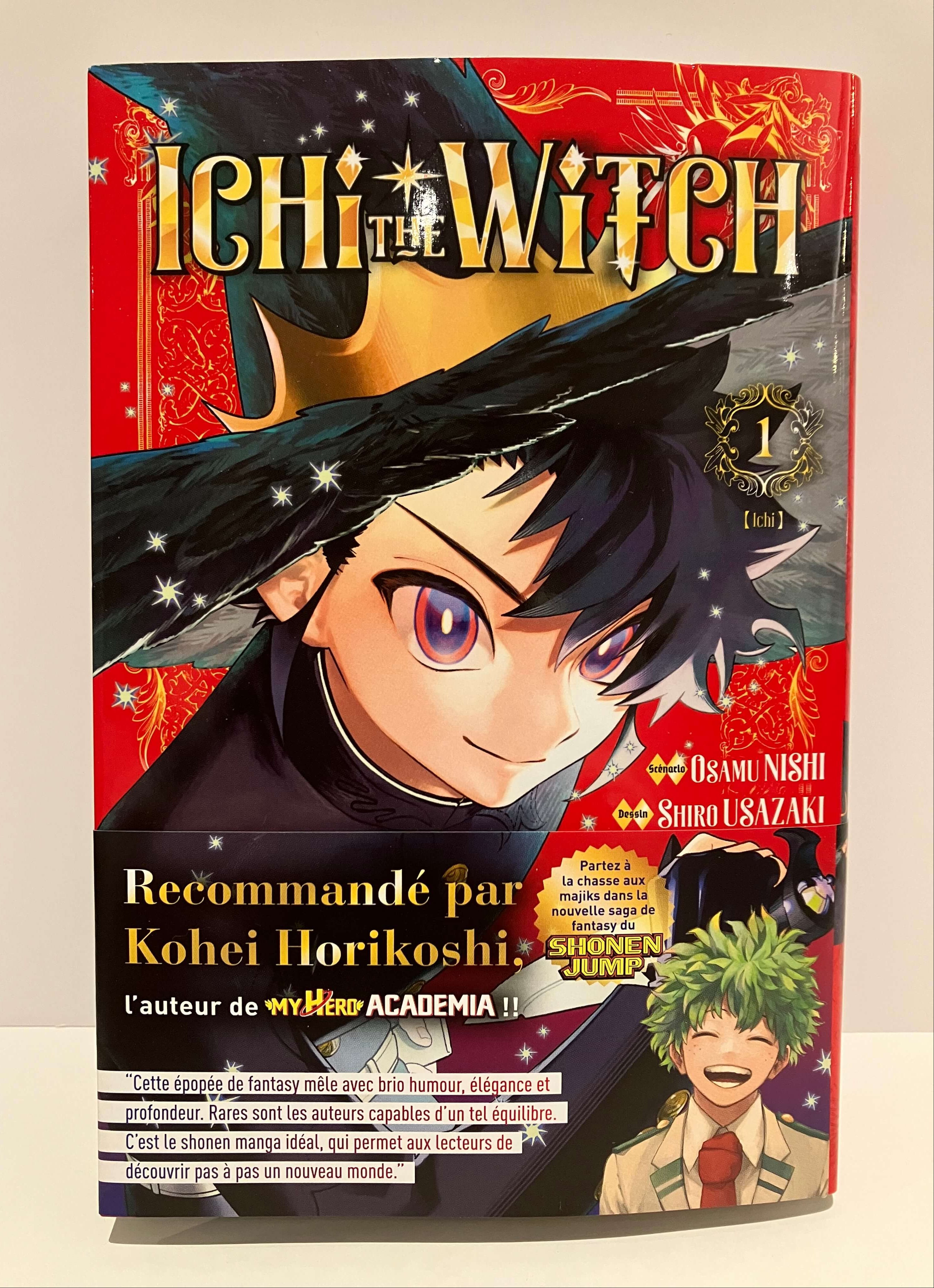 un jeune garçon aux yeux violets et chapeau noir sur fond rouge orné d’étoiles