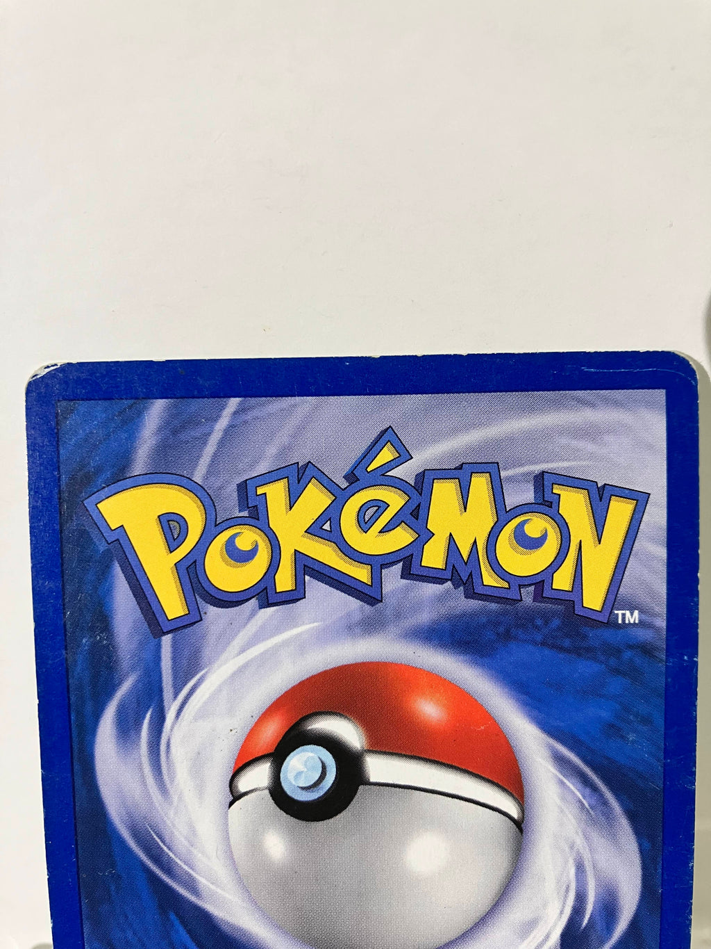 Dos de carte Pokémon avec logo jaune, Pokéball et bordure bleue sur fond blanc