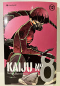 Couverture de Kaiju No 8 tome 12 avec un personnage masqué en costume, fond rose, manga Naoya Matsumoto
