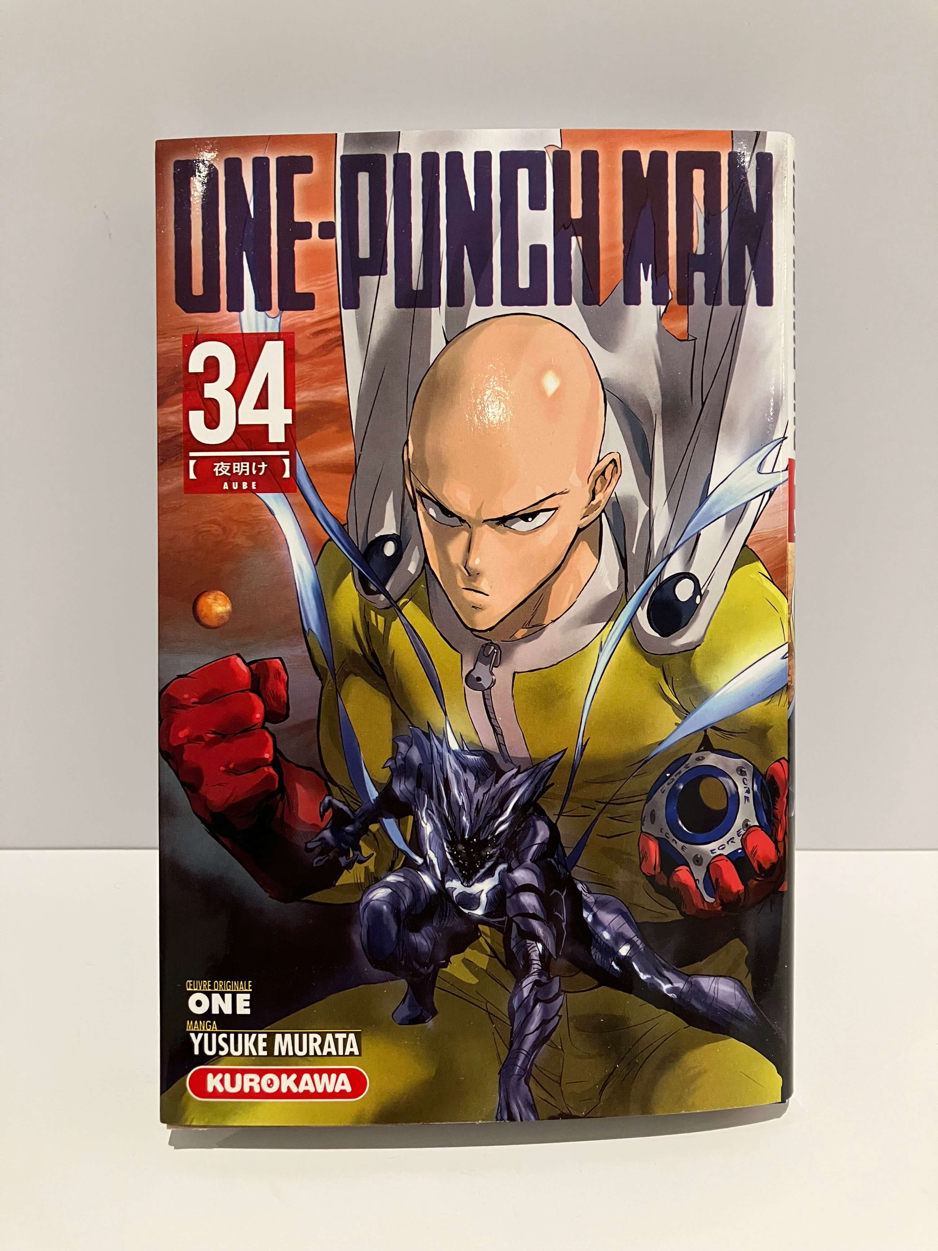 Couverture de One Punch Man tome 34 : un super-héros chauve en cape blanche et costume en jaune est prêt à se battre 