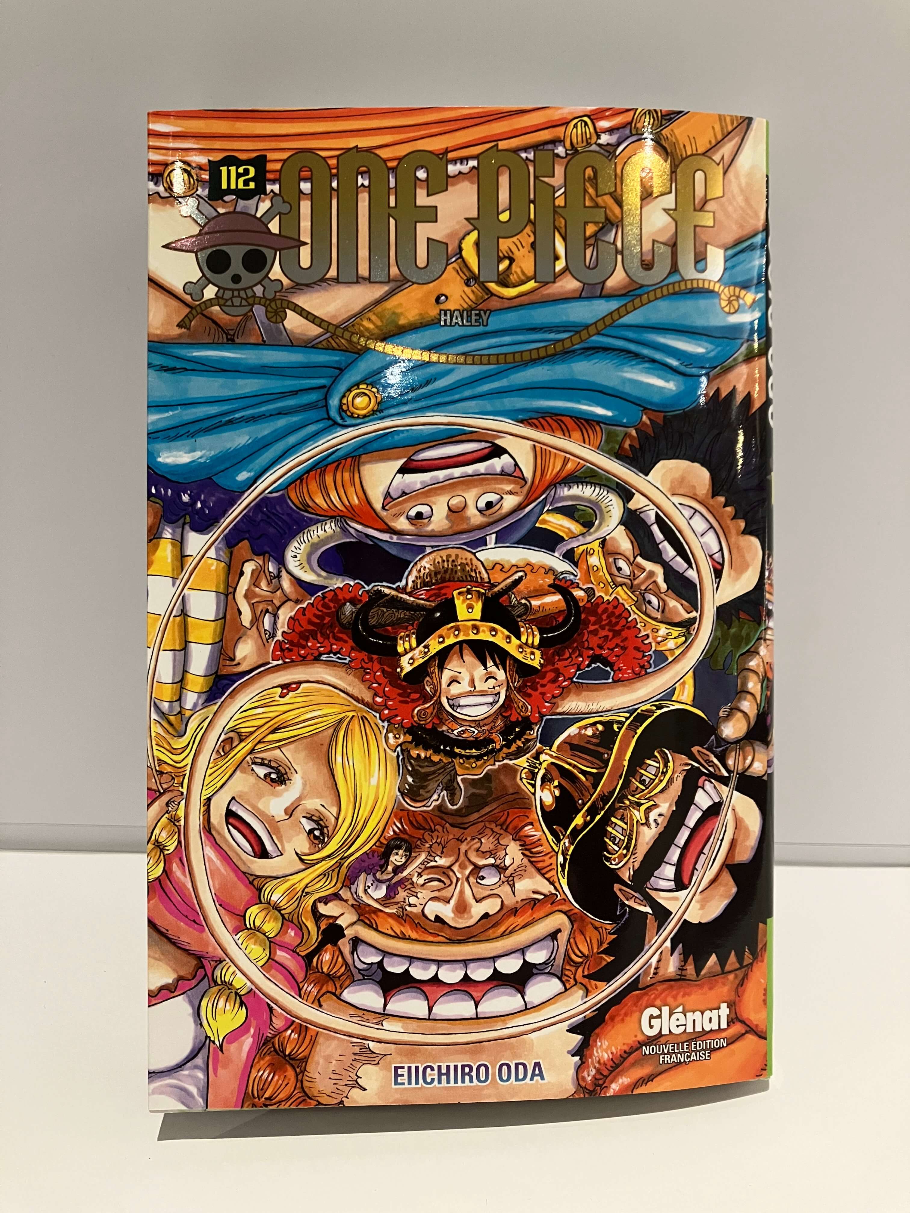 Couverture du manga One Piece tome 112 : plusieurs personnages souriants entourent Luffy au centre, dans une composition colorée et dynamique.