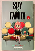 Couverture du manga Spy x Family tome 2 avec Anya assise sur un banc coloré, peluche à côté.