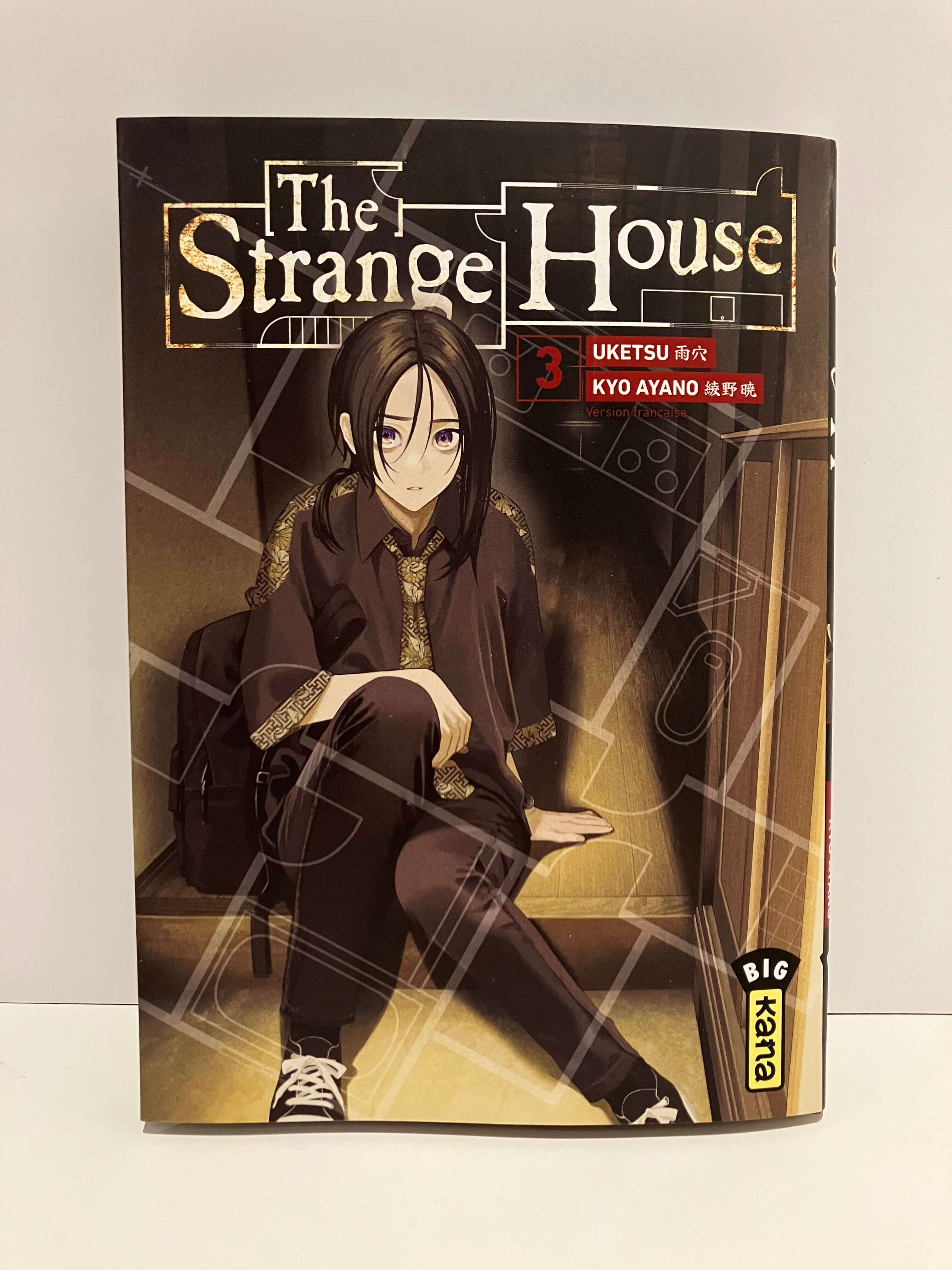 couverture de manga the strange house tome 3 : une fille assise à l'entrée de la maison