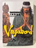 Couverture de Vagabond tome 28 avec un homme en kimono, mains jointes, statue japonaise à gauche.