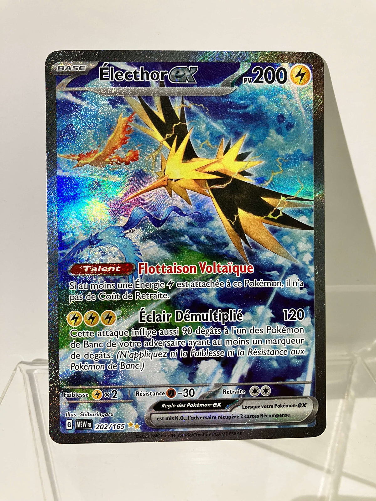 Carte Pokémon Électhor EX brillante, illustrant un oiseau électrique sur fond bleu